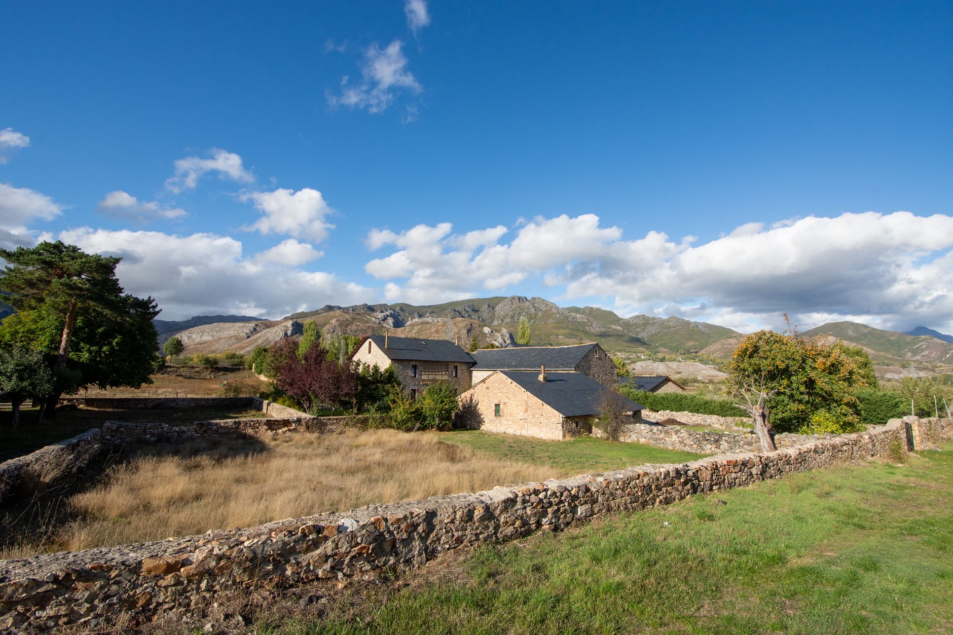 Picturesque stone house with slate roof in scenic mountain landscape, perfect for rural retreat.