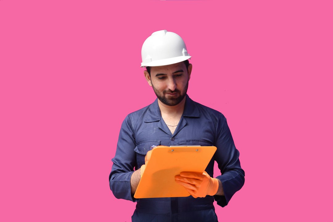 a person wearing a hard hat and holding a yellow folder