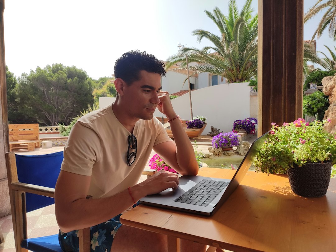 a person sitting at a table with a laptop